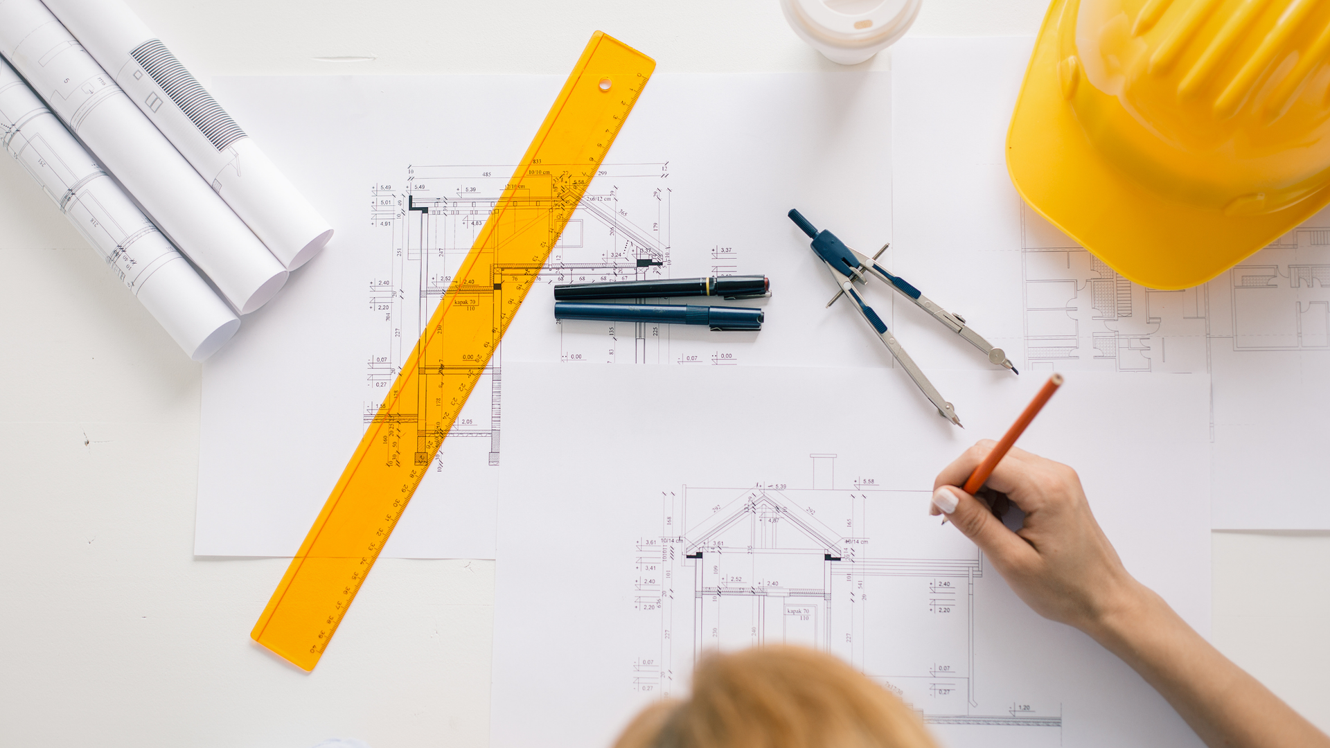 Person drawing a blueprint.